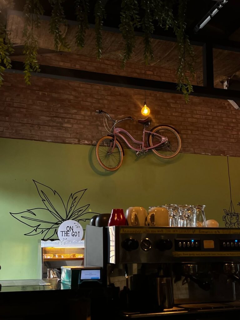 Inside The Green Door Café — exposed brick, an olive-green wall and a vintage bicycle